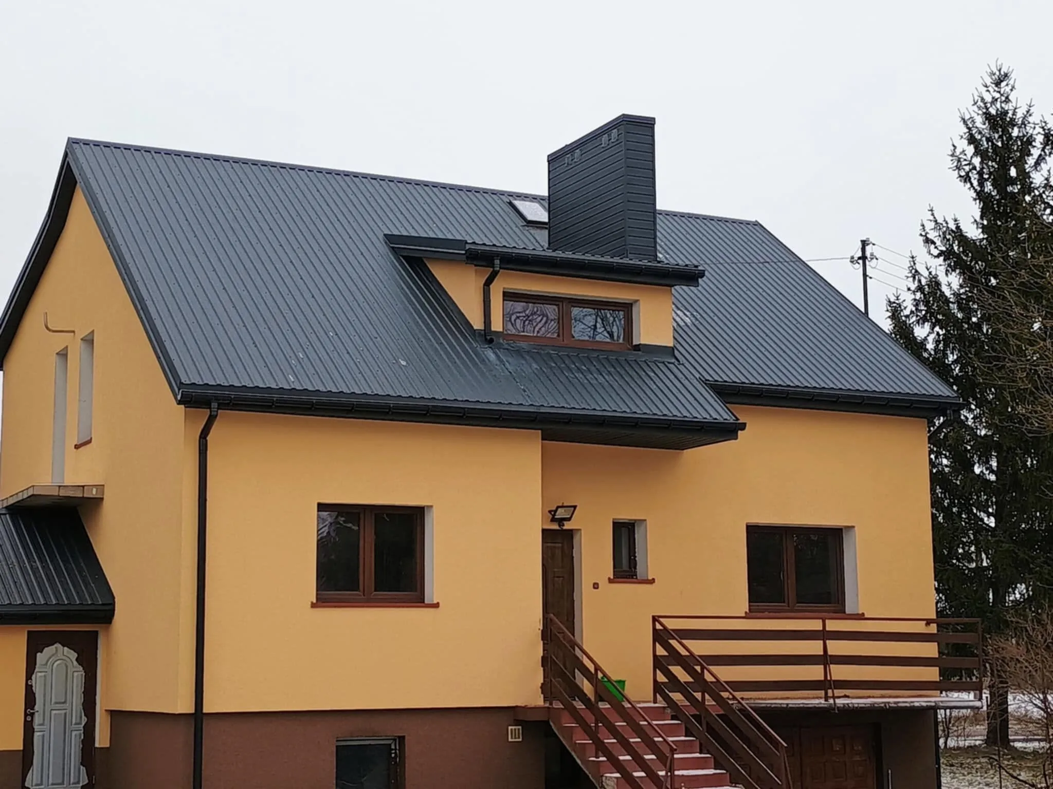 Dom z nowym pokryciem dachowym z blachodachówki i lukarną